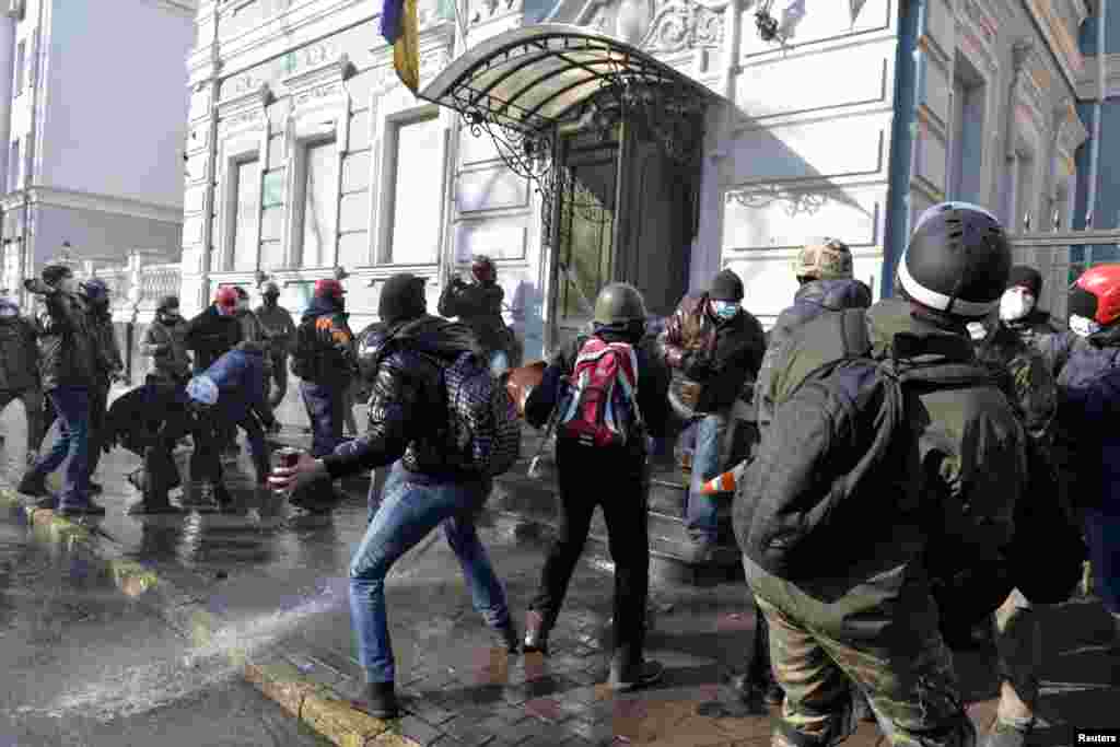 Anti-government protesters throw stones at the office of the pro-presidential Party of the Regions, Kyiv, Feb. 18, 2014.