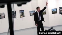 Seorang pria yang diidentifikasi sebagai Mevlut Mert Altintas berteriak seusai menembak Andrei Karlov, Dubes Rusia untuk Turki di sebuah Galeri Foto di Ankara,Turki, 19 Desember 2016 (AP Photo/Burhan Ozbilici).
