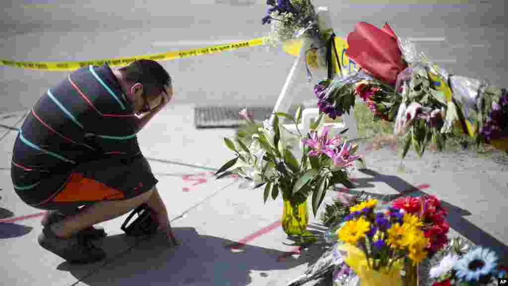 Noah Nicolaisen, de Charleston, Caroline du Sud, s’agenouille en mémoire des victimes, jeudi 18 Juin 2015, à l'endroit où un homme a ouvert le feu et tué neuf personnes en réunion de prière à l'intérieur de l’église AME Emanuel.