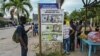 Un migrante varado mira un cartel sobre inversiones en Necoclí, Colombia, el 29 de julio de 2021.