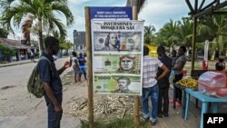 Un migrante varado mira un cartel sobre inversiones en Necoclí, Colombia, el 29 de julio de 2021.