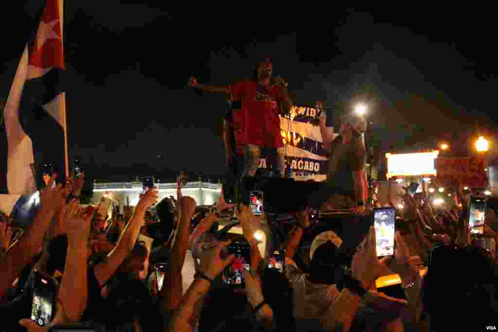 Yotuel, ex integrante de Orishas interpreta "Patria y Vida" para exiliados que se reunieron en la Calle 8 en Miami, Florida, en apoyo a las protestas sucedidas en la isla el domingo 11 de julio de 2021. Foto: Luis F. Rojas, VOA.