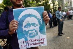 FILE - Iranian and Nigerian students hold posters of Nigerian Shiite cleric Ibrahim El-Zakzaky during a demonstration outside the Nigerian Embassy in Tehran, July 17, 2019.