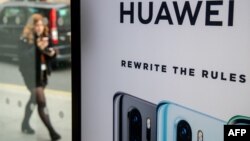 2019年4月29日行人走過英國倫敦市中心EE電信商店華為產品展台。