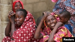 Para anggota keluarga meratapi para siswi di Dapchi, negara bagian Yobe, Nigeria, yang hilang setelah serangan oleh militan Boko Haram, hari Jumat (23/2). 