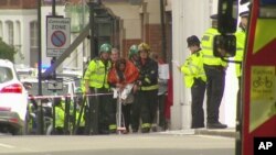 Dalam gambar yang diambil dari video ini, seorang perempuan menyelimuti badannya dengan selimut, dikawal oleh petugas layanan darurat di dekat lokasi ledakan di London, Jumat, 15 September 2017. (Sky via AP)