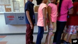 Anak-anak imigran yang ditahan berbaris di kafetaria di Pusat Pemukiman Kabupaten Karnes, rumah sementara bagi wanita dan anak-anak imigran yang ditahan di perbatasan, di Karnes City, Texas, 10 September 2014. (Foto: AP)