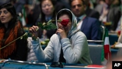 Una mujer iraní estadounidense que apoya al Consejo Nacional de Resistencia de Irán lleva una rosa en el Centro de Convenciones de Los Ángeles, el sábado 11 de enero de 2020. 