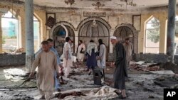 Warga memeriksa kerusakan di dalam masjid di Kunduz, Afghanistan, setelah serangan bom berlangsung saat sholat Jumat (8/10).