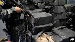 Un agente policial supervisa un cargamento de droga recuperado y a punto de ser incinerado en Cayambe, Ecuador, el 21 de abril de 2022. El gobierno nacional declaró terroristas a varias bandas vinculadas al narcotráfico internacional en abril de este año.