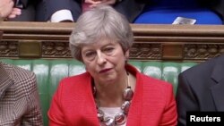 FILE - British Prime Minister Theresa May reacts after tellers announced the results of the vote Brexit deal in Parliament in London, Britain, March 12, 2019, in this screen grab taken from video.