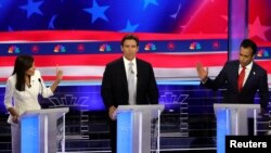 El gobernador de Florida, Ron DeSantis, hace un gesto mientras la exgobernadora de Carolina del Sur, Nikki Haley, y el exejecutivo Vivek Ramaswamy discuten en el tercer debate presidencial republicano en Miami, Florida el 8 de noviembre de 2023