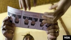 Relawan Pemilu menyerahkan kertas suara pada pemilu 2009 lalu di Denpasar Bali. Pengamat dari IDEA mengatakan proses politik dan teknologi informasi menjadi tantangan pemilu saat ini. (Foto: dok)