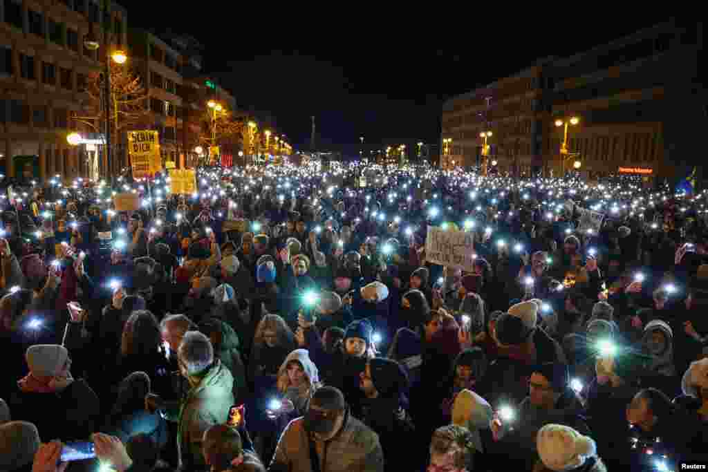 People light up their mobile phones during a protest against the migration plans of the CDU party leader and top candidate for Chancellor Friedrich Merz and the far-right Alternative for Germany party (AfD), in Berlin. 