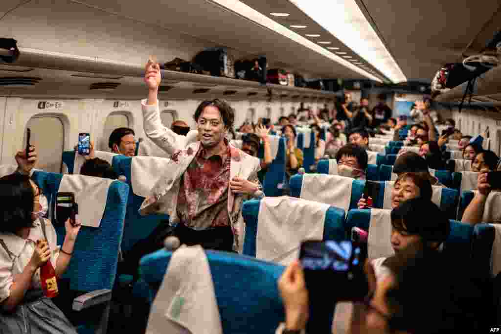 Passengers take pictures of a performer during the 'Zombie Shinkansen' event on a bullet train from Tokyo to Osaka, Japan, ahead of Halloween, Oct. 19, 2024.
