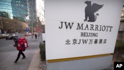 A deliveryman walks near entrance of a JW Marriott hotel in Beijing, China, Jan. 11, 2018.