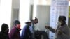Un agent de la santé converse avec des volontaires pour le test d'un vaccin anti-COVID-19, à l'hôpital Chris Hani Baragwanath de Soweto, à Johannesburg, le 24 juin 2020. (AP Photo)