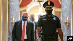 FILE - In this Aug. 5, 2020, file photo Postmaster General Louis DeJoy, left, is escorted to a meeting in House Speaker Nancy Pelosi's office on Capitol Hill in Washington.