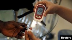 FILE - A paramedic checks the blood sugar level of a patient at a diabetes clinic in Jakarta, Indonesia, April 22, 2016.