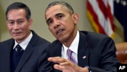 Dieu Cay of Vietnam listens at left as President Barack Obama answers a question about the situation in Baltimore during a meeting in the Roosevelt Room of the White House in Washington, May 1, 2015.