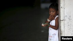 A young Rohingya migrant who arrived in Indonesia last week by boat eats a snack at a temporary shelter in Aceh Timur regency near Langsa in Indonesia's Aceh Province, May 26, 2015.