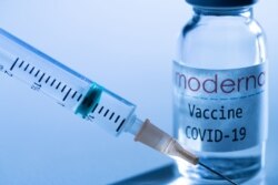 Esta imagen creativa tomada en un estudio en París el 16 de noviembre de 2020, que muestra una jeringa y un frasco de vacuna con el logo reproducido de una firma de biotecnología estadounidense Moderna.