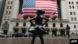FILE - The Fearless Girl statue stands in front of the New York Stock Exchange near Wall Street in New York City, March 23, 2020.