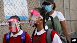 Para siswa mengenakan masker dan pelindung wajah saat tiba untuk belajar di sebuah sekolah di Bronx, New York.