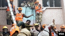 Para petugas penyelamat melakukan evakuasi dengan menggunakan tali setelah kebakaran melanda rumah sakit Kolkata, India (9/12).