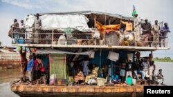 Southern Sudanese people arrive in a barge at the port in Juba, August 31, 2012. 