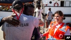 Migrants disembark from the the Open Arms boat, in Algeciras, Spain, Aug. 9, 2018, after being rescued off the coast of Libya.