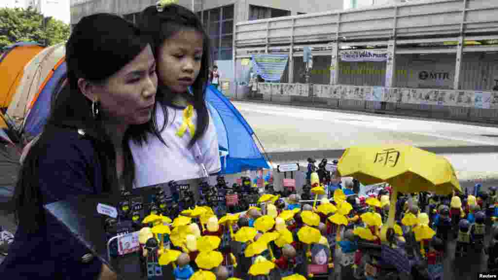 Occupy central supporters look at a scene of protesters, depicted by Lego characters , confronting riot police, outside the government headquarters in Hong Kong, Oct. 20, 2014.