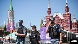 ARHIVA - Ruska policija i članovi Nacionalne garde noseći maske šetaju po Crvenom trgu u Moskvi, 18. juna 2021.