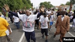 Les manifestants, dont le père de Michael Brown (centre, arrière-plan), ont marché le long d'une des avenues de Ferguson, le 8 août 2015.