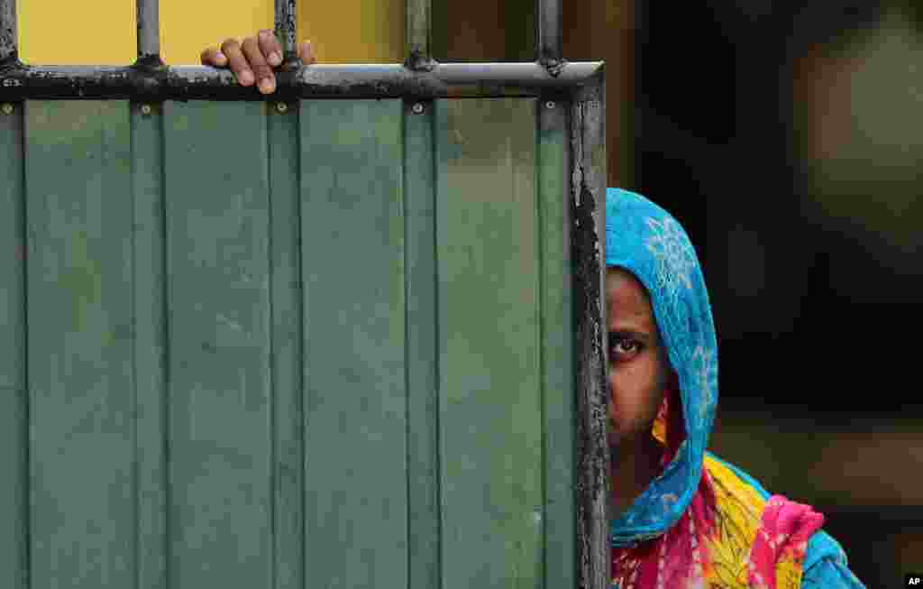 Seorang perempuan muslim Sri Lanka mengawasi jalan dari rumahnya di kota Aluthgama, di mana terjadi kekerasan sektarian terhadap minoritas muslim oleh kelompok radikal Budha.