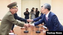 지난 8월 판문점에서 열린 남북 고위급 회담에서 북측 대표인 김양건 당 비서(왼쪽)가 한국측 대표인 김관진 한국 국가안보실장과 악수하고 있다. (자료사진)