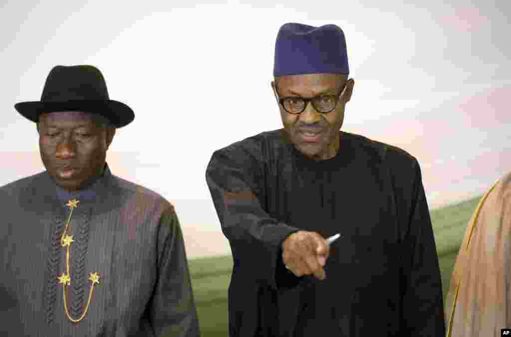 Le candidat de l'opposition, le général Muhammadu Buhari, à droite, et le président Goodluck Jonathan du Nigeria, à gauche, se préparent à renouveler leur engagement à organiser des élections pacifiques "libres, justes et crédibles", dans un hôtel de la capitale Abuja, Nigeria jeudi 26 mars 2015.