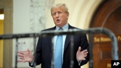 El expresidente Donald Trump habla mientras regresa a la sala del tribunal después de la pausa para el almuerzo de su juicio civil por fraude empresarial, el miércoles 18 de octubre de 2023, en la Corte Suprema de Nueva York, EEUU.