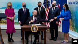 President Joe Biden hands a pen to Interior Secretary Deb Haaland after signing an executive order to help improve public safety and justice for Native Americans during a Tribal Nations Summit on Nov. 15, 2021, in Washington. 
