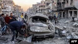 Raia akichunguza gari lililoharibika kufuatia mapigano yanayoendelea katika mitaa ya Gaza City. January 14, 2025. 
