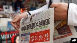 一个中国人拿着《环球时报》，2010年。(资料图)