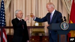 資料照片：2015年7月7日，時任美國副總統喬·拜登(右)與越南共產黨總書記阮富仲在華盛頓國務院舉行的歡迎午餐會上，共同舉杯。 （美聯社照片）