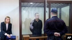 FILE - Journalist Andrzej Poczobut, center, stands in a defendants' cage during a court session in Grodno, Belarus, Jan. 16, 2023. Belarus' Supreme Court upheld an eight-year prison sentence against Poczobut on May 26, 2023.