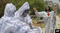 El cuerpo de una víctima de COVID-19 es preparado para ser enterrado en un cementerio cristiano en Nueva Delhi, India, el sábado 29 de mayo de 2021.