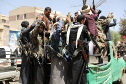 Armed Houthi followers ride on the back of a truck outside a hospital in Sanaa, Yemen, April 8, 2020.