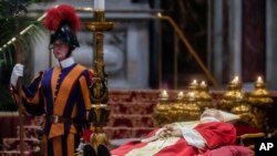 Un guardia suizo permanece de pie junto al cuerpo del papa emérito Benedicto XVI en la Basílica de San Pedro, a donde miles de personas acudieron para rendirle homenaje, en el Vaticano. 