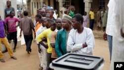 Des Nigérians attendent de voter dans un bureau de vote à Abuja, Nigeria, samedi 28 mars2015. 