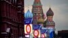 La gente se prepara para un concierto en la Plaza Roja, con construcciones que dicen las palabras "Donetsk, Luhansk, Zaporiyia y Jersón, son Rusia" y la Catedral de San Basilio y el Mausoleo de Lenin al fondo, en Moscú, el 29 de septiembre de 2022.