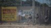 Un oficial de policía lanza gas lacrimógeno a los manifestantes durante una protesta para rechazar una fuerza militar internacional solicitada por el gobierno y exigir la renuncia del primer ministro Ariel Henry, en Puerto Príncipe, Haití, el 17 de octubre de 2022.