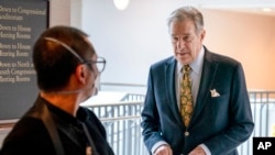 ARCHIVO - Paul Pelosi, a la derecha, esposo de la presidenta de la Cámara de Representantes, Nancy Pelosi, de California, sigue a su esposa cuando llega a su conferencia de prensa semanal en el Capitolio de Washington el 17 de marzo de 2022.